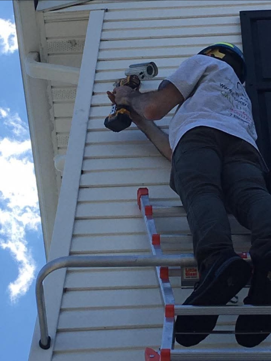 Crew member mounting an exterior security camera