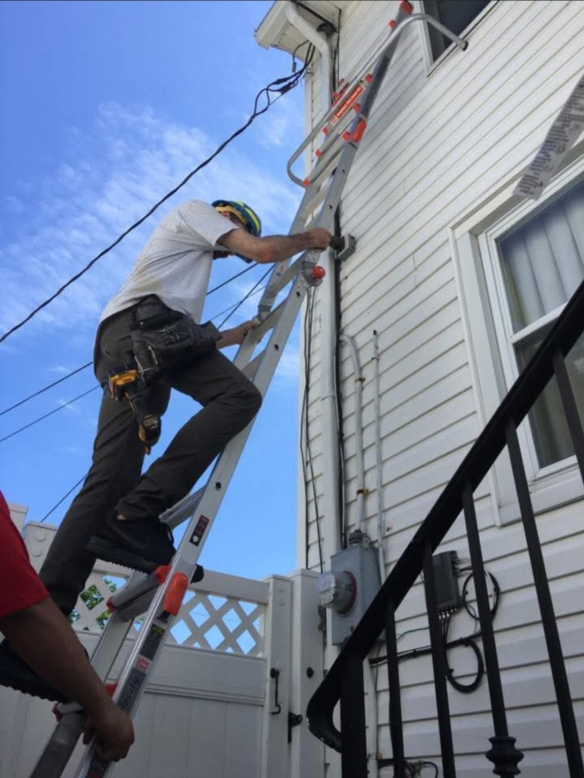 Crew member installing exterior wiring and connections