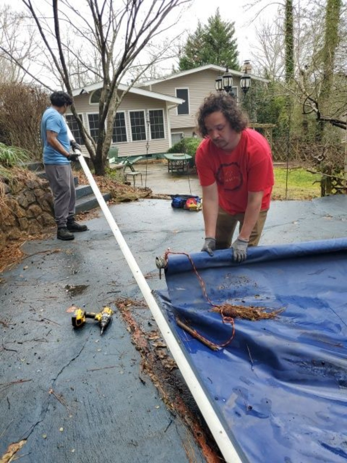Two crew members working together on pool-cover equipment